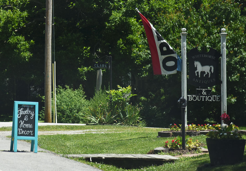 Whitehorse Antiques and Boutique displays an open flag and sign for customers